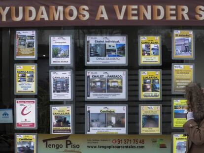 Una mujer pasa junto a una inmobiliaria en Madrid.