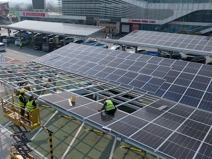 Trabajadores instalan paneles fotovoltaicos en un área de servicio en la autopista Jinan-Heze, la primera con cero emisiones de carbono de China, el 9 de marzo.