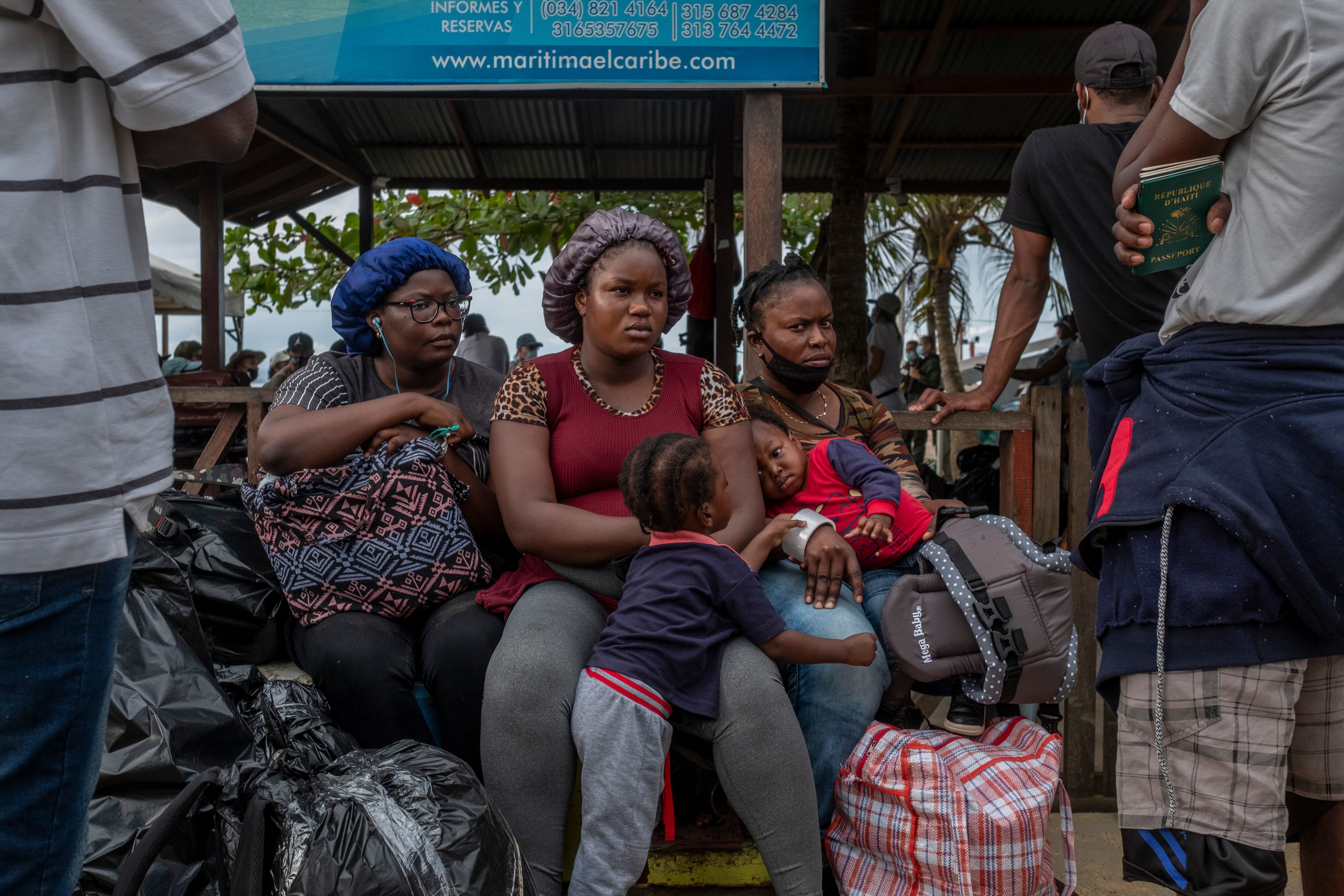 Un grupo de mujeres migrantes de haití y sus hijos esperan su turno para poder abordar una lancha desde Necoclí (Colombia) hasta Capurgana, para luego cruzar el Tapón del Daríen y así llegar a Panamá, en agosto de 2021. 