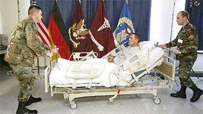 Dos soldados de EE UU trasladan a uno de los heridos en el derribo de un helicóptero Chinook en Irak ayer en el hospital alemán de Landshut.