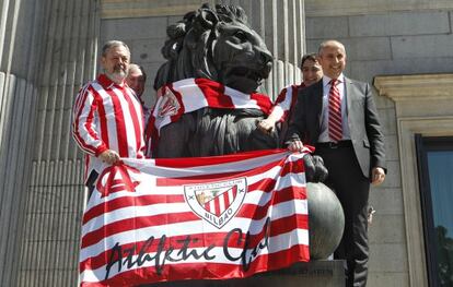 Diputados del PNV colocan una bufanda del Athletic de Bilbao a un le&oacute;n del Congreso de los Diputados.