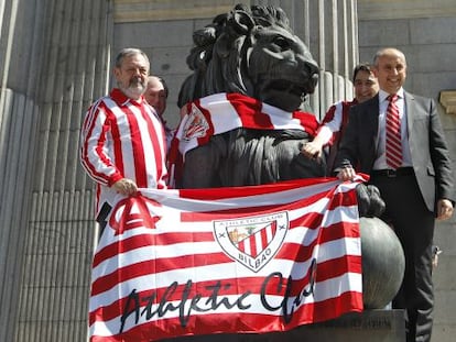 Diputados del PNV colocan una bufanda del Athletic de Bilbao a un le&oacute;n del Congreso de los Diputados.