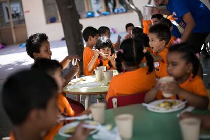 Niños durante la hora de la comida en el comedor del Casal Social de la Fundación Pere Tarres en la escuela Vedruna del Raval.
