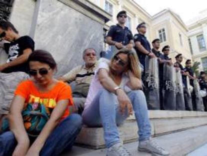 Trabajadores de la radiotelevisión pública griega ERT delante de las escaleras del Consejo de Estado (tribunal administrativo en el país), en Atenas (Grecia).