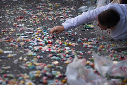 Un niño recoge un caramelo tras el paso de la cabalgata de 2023 en Sevilla. 