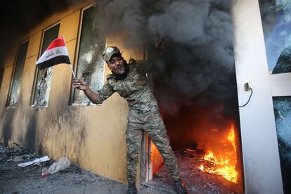 Un soldado sostiene una bandera iraquí tras el asalto a la Embajada de Estados Unidos en Bagdad, este martes.
