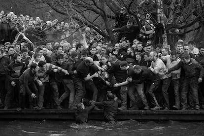 Imagen captada por el fotógrafo Oliver Scarff, ganador del primer premio de la categoría 'Sports - Singles'. La foto muestra a los miembros de equipos contrarios, los Up'ards y Down'ards, luchando por el balón durante el histórico y anual partido de fútbol Royal Shrovetide en Ashbourne, Derbyshire (Reino Unido), el 28 de febrero de 2017. 