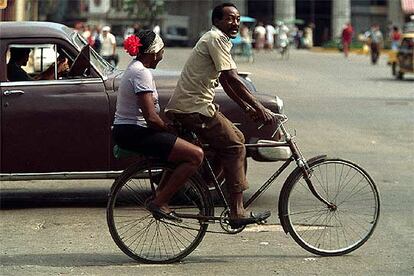 Una pareja se traslada en bicicleta por las calles de la Habana Vieja.