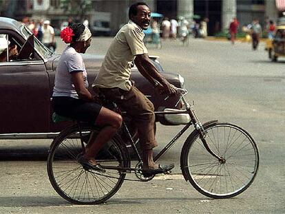 Una pareja se traslada en bicicleta por las calles de la Habana Vieja.