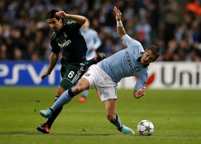 El jugador del Manchester City, Aleksandar Kolarov, pelea por el control del balón con el centrocampista alemán del Real Madrid, Sami Khedira.