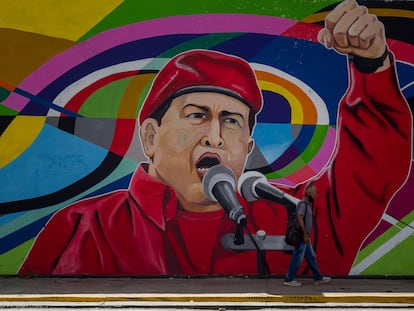 Um homem caminha ao lado de um mural sobre o falecido presidente venezuelano Hugo Chávez, em 8 de novembro de 2021 em Caracas, Venezuela.