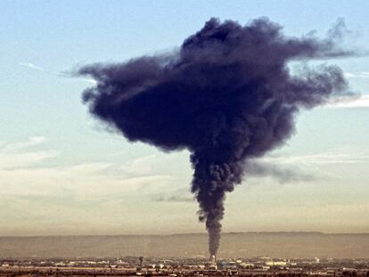 La enorme columna de humo negro provocada por el fuego en el almacén de tinta abandonado se alza sobre Alcalá de Henares.