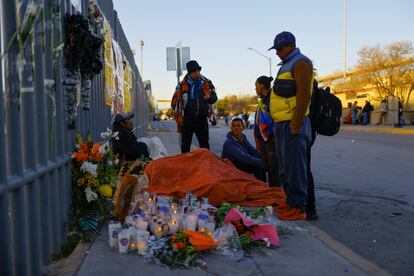 En Ciudad Juárez, los altares y los homenajes a los migrantes fallecidos continúan a las afueras del centro del Instituto Nacional de Migración. En la imagen, un grupo de migrantes junto a una ofrenda en honor a los fallecidos en el incendio.