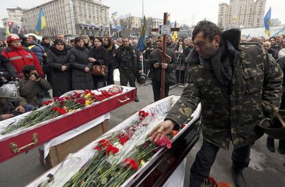 Decenas de personas muestran su respeto a los caídos durante los enfrentamientos con la policía, en los últimos días, en el centro de Kiev, 22 de febrero de 2014. 