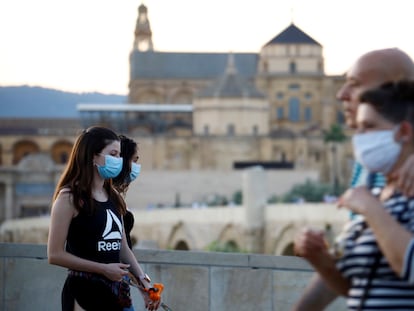 Ciudadanos protegidos con mascarillas pasean por las inmediaciones de la Mezquita y la Catedral de Córdoba.