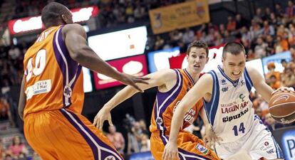 El base del Lagun Aro, Javier Salgado, trata de superar la defensa de los jugadores del Valencia Basket, el base San Miguel y el ala pívot francés Pietrus.