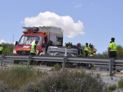 Los bomberos rescatan a una de las víctimas mientras un fallecido permanece sobre el asfalto.