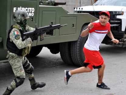 Un soldado del Ejército mexicano apunta su rifle a un hombre que lo acusó de participar en la masacre de Nuevo Laredo