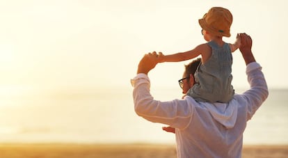 Un padre y su hijo pasean por la playa.