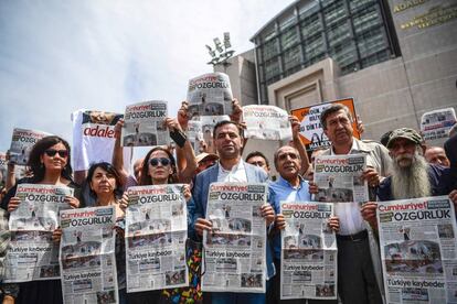 Manifestantes sostienen copias de la edici&oacute;n de este viernes del diario &#039;Cumhuriyet&#039; frente a los tribunales de Estambul donde tiene lugar el juicio contra varios empleados y directivos de este peri&oacute;dico progresista.