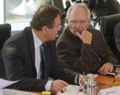 El ministro del Interior alemán, Hans-Peter Friedrich (der), charla con el ministro de Finanzas alemán, Wolfgang Schäuble (izq), durante el Consejo de Ministros en Berlín, Alemania, hoy.