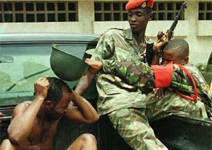 Un soldado de Sierra Leona golpea con un casco a un detenido, acusado de saquear tiendas en Freetown, en 1997.