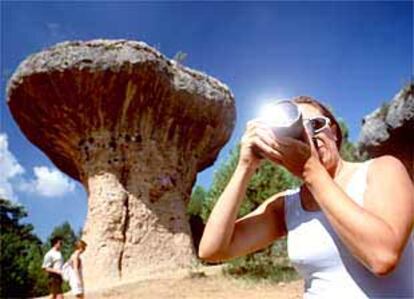 Una turista toma fotos en la Ciudad Encantada. Detrás, el Frutero, roca en forma de seta.