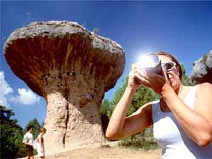 Una turista toma fotos en la Ciudad Encantada. Detrás, el Frutero, roca en forma de seta.
