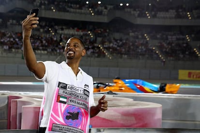 El actor norteamericano Will Smith se hace una fotografía mientras el piloto español Fernando Alonso compite en la carrera.