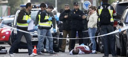 Varios polic&iacute;as nacionales observan el cuerpo de Rulber Delgado, tiroteado en la calle de Poniente en Coslada. 