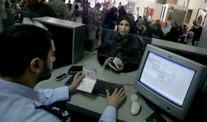 Una mujer palestina sella su pasaporte en el puesto fronterizo de Rafah, entre Egipto y Gaza.