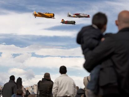 Unos espectadores observan el vuelo de tres aviones de la colección de la Fundación Infante de Orleans, en Cuatro Vientos.