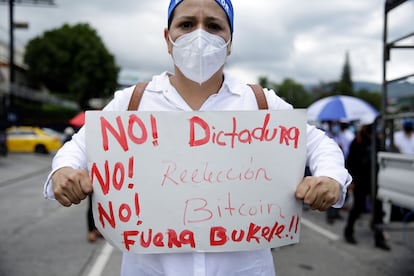 Una mujer muestra un cartel de protesta contra el Gobierno de Nayib Bukele, durante la manifestación de este miércoles, en San Salvador.