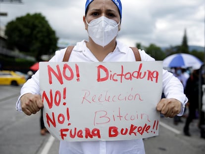 Una mujer muestra un cartel de protesta contra el Gobierno de Nayib Bukele, durante la manifestación de este miércoles, en San Salvador.