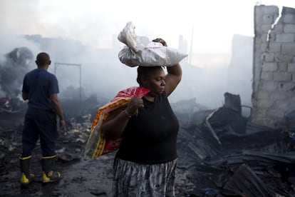 Una mujer camina tras un incendio en el mercado central de Puerto Príncipe (Haití).