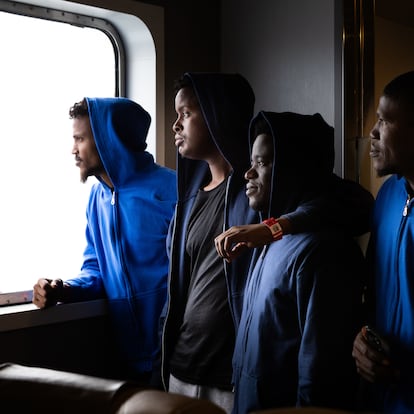 Migrantes somalíes que llegaron en patera a Mallorca miran por la ventana del ferri que los traslada a Barcelona. 08/07/2025