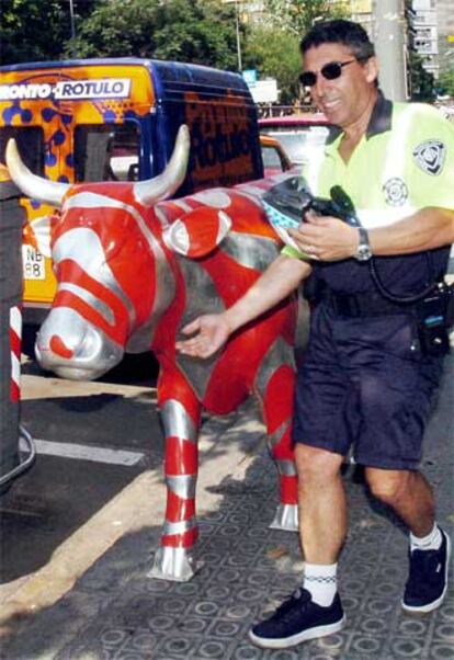 Un guardia urbano de Barcelona muestra la vaca que desapareció el pasado lunes.