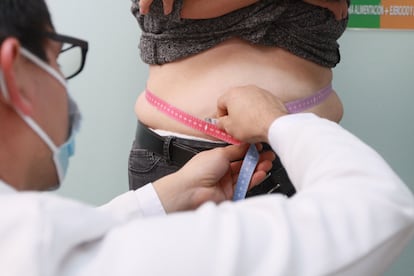 Un médico toma las medidas a una mujer con sobrepeso, en un hospital del IMSS.