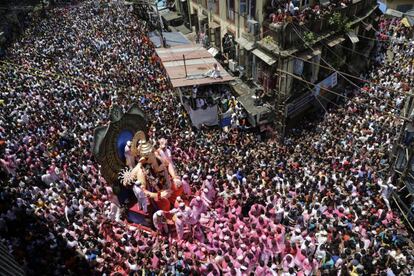 Devotos indios portan una estatua de la deidad hindú con cuerpo de hombre y cabeza de elefante, el dios Ganesha, antes de su tradicional inmersión en el mar durante la celebración del festival de Ganesha, en Bombay, la India.