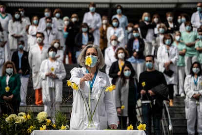 Una sanitaria del Hospital Gregorio Marañón coloca un narciso en homenaje a los muertos por la covid-19.