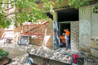 Unos operarios colocan una puerta antiokupación en un edificio de Zaragoza.