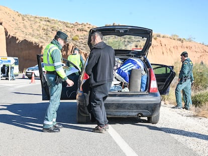 Un guardia civil inspecciona el maletero de un vehículo que abandona la zona de la 'rave' de La Peza (Granada), este miércoles.