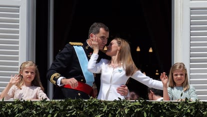 La reina Letizia besa a su marido, el rey Felipe, junto a la princesa Leonor (izquierda) y la infanta Sofía en el saludo de la Familia Real desde balcón del Palacio Real de Madrid al público congregado durante los actos de proclamación del rey Felipe VI, el 19 de julio de 2014.
