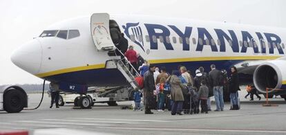 Desenes de passatgers pugen a un avió de Ryanair.