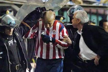 El entrenador del Boca, Jorge Benítez, escupe al delantero del Chivas Bautista.