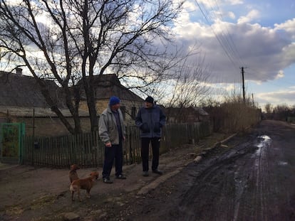 Vasili Grebinik y su vecino Valeri Gobreyev frente a sus casas en Mariinka.