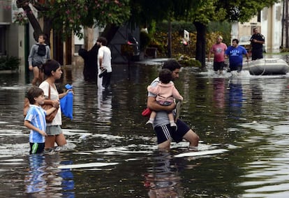 Una familia se traslada a un lugar más seguro tras las fuertes lluvias caídas en la ciudad argentina de La Plata.