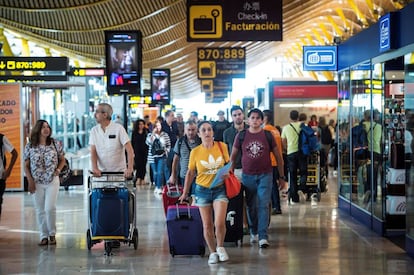 Viajeros transitan por la terminal 4 del aeropuerto de Barajas al inicio de las vacaciones del mes de agosto.