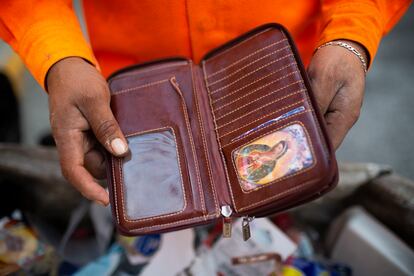 Juan Cruz Ubaldo revisa una cartera que ha encontrado en la basura.