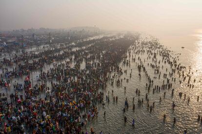 Devotos hindúes se reúnen para darse un baño sagrado en la bahía de Bengala durante el Gangasagar Mela, en la isla Sagar (India).